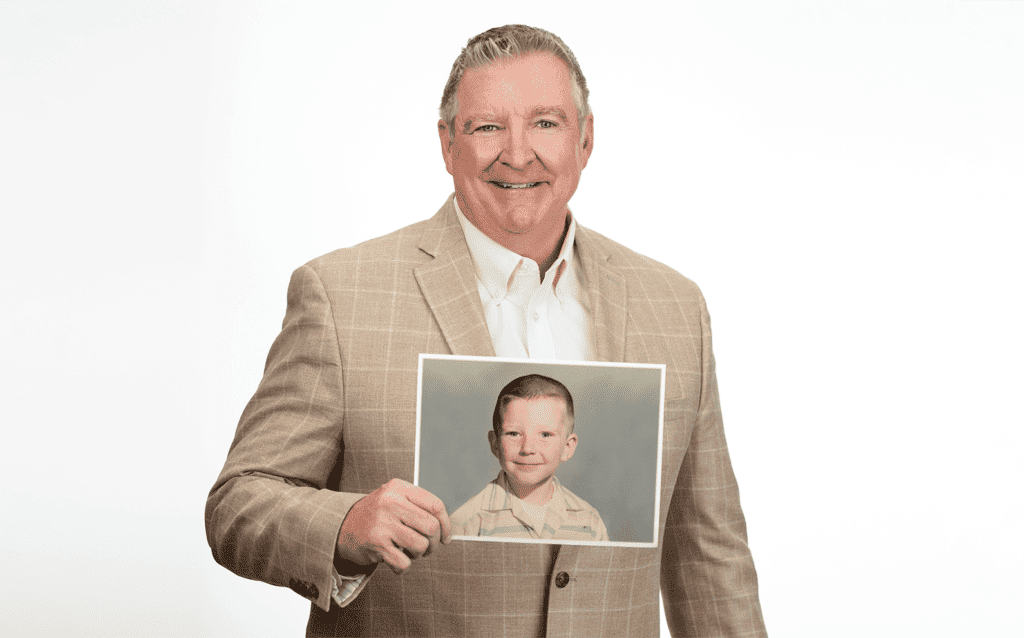 Photo of Jim Daly holding up a photo of himself as a child