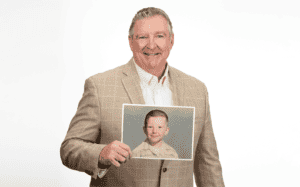 Photo of Jim Daly holding up a photo of himself as a child