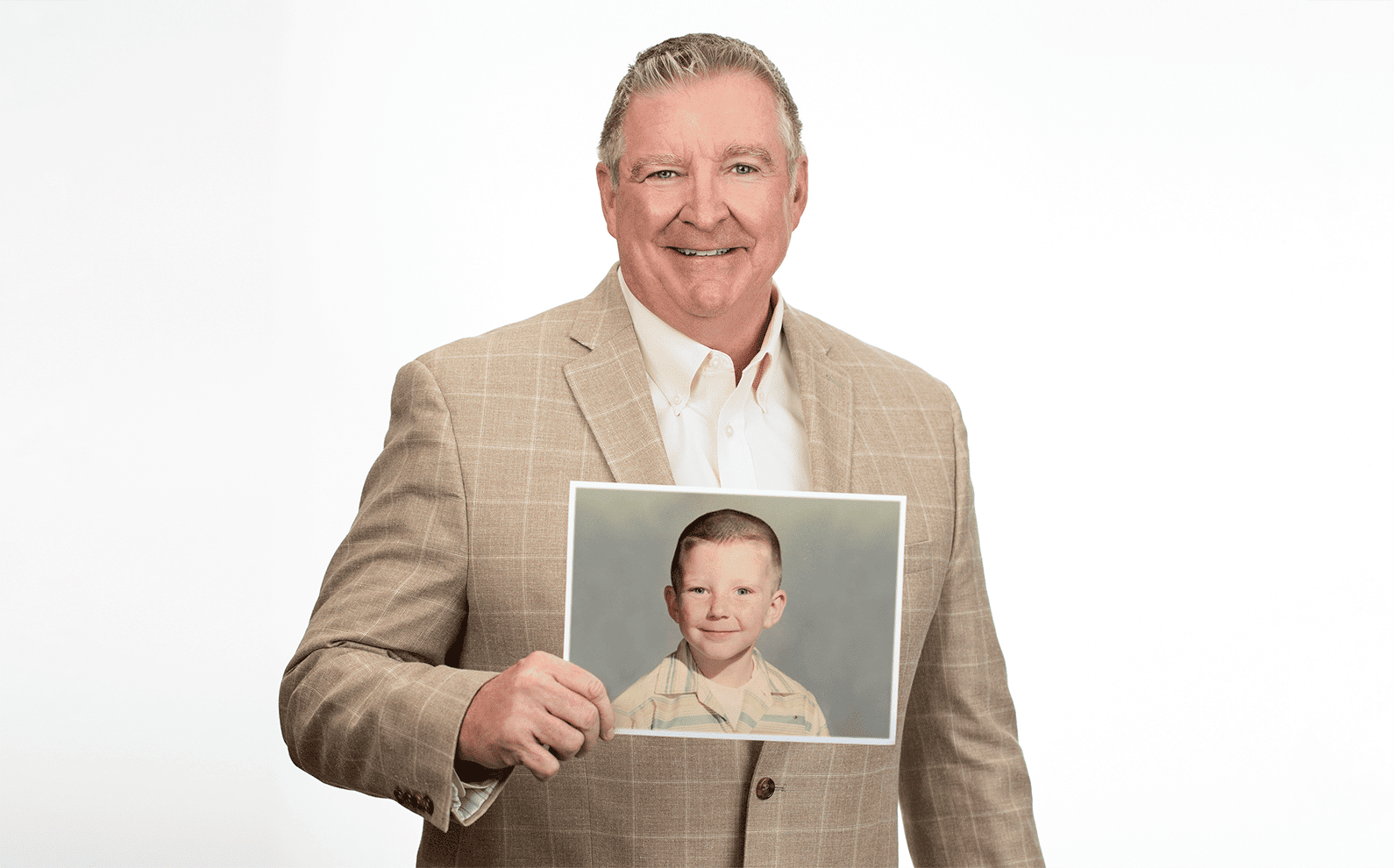 Photo of Jim Daly holding up a photo of himself as a child