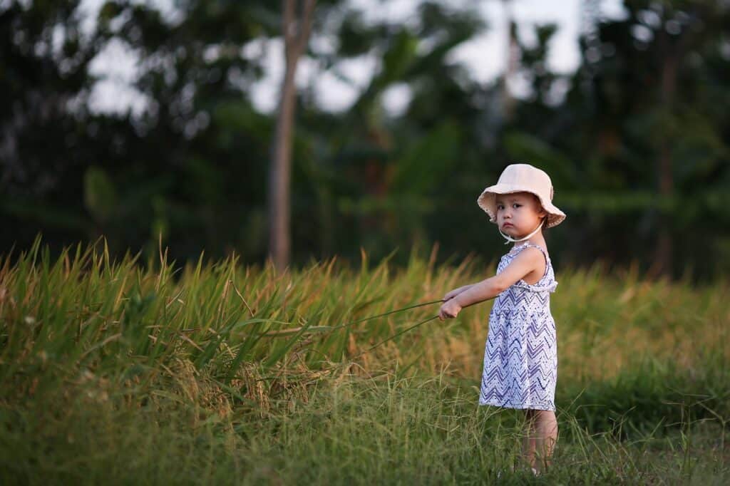 unhappy little girl in field of grass