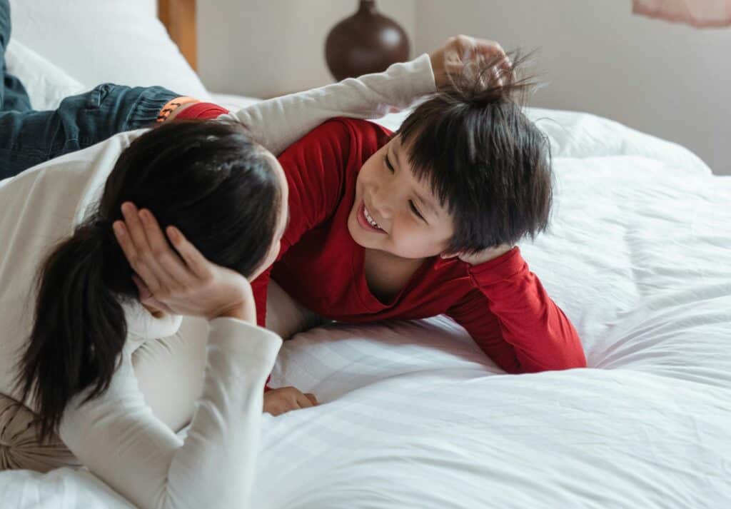 mom talking to young son on bed