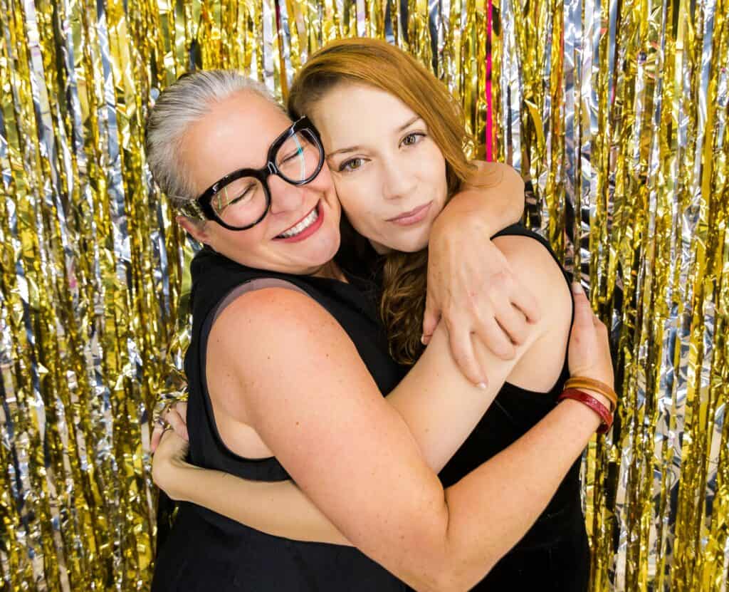 Mom hugging young adult daughter at event