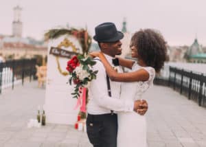 Black-newlyweds-happily-hugging-at-wedding-reception-on-rooftop
