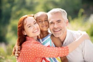 Photo of a wife and husband with adopted/foster care child.