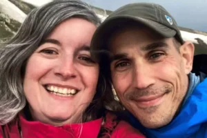A smiling couple, Carrin and Jeremy Eyman, takes a close-up selfie outdoors, symbolizing their journey of resilience and support while facing military PTSD.
