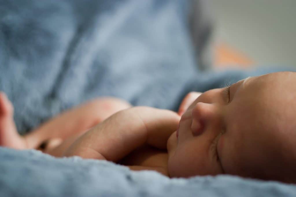 Newborn baby sleeping on a blanket.