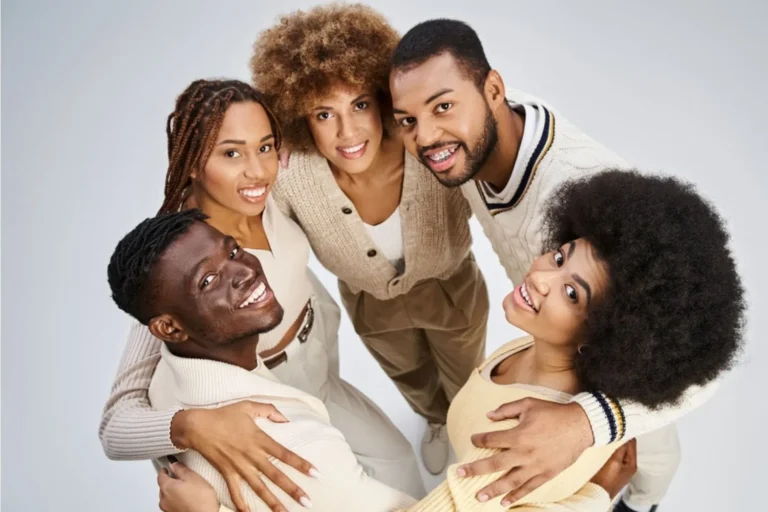 Five young adults in a circle looking up and celebrating happy Juneteenth