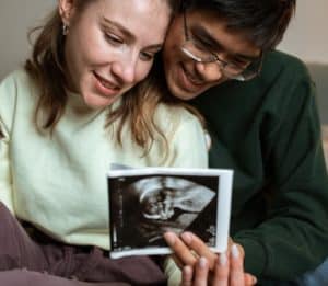 Man and woman looking happily at ultrasound