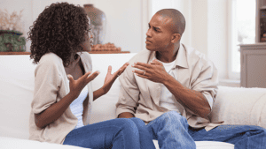 Black-husband-and-wife-arguing-while-sitting-on-couch