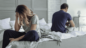 Unhappy-married-couple-sitting-on-bed-not-looking-at-each-other