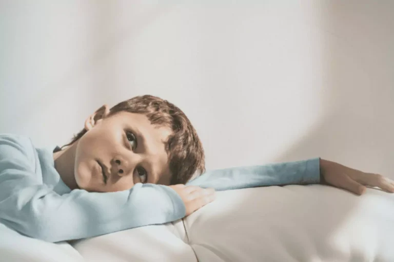 Boy with his head on his arm looking sad