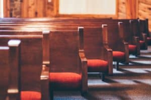 Photo of empty church pews all in a row