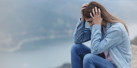 A young upset woman sitting outside