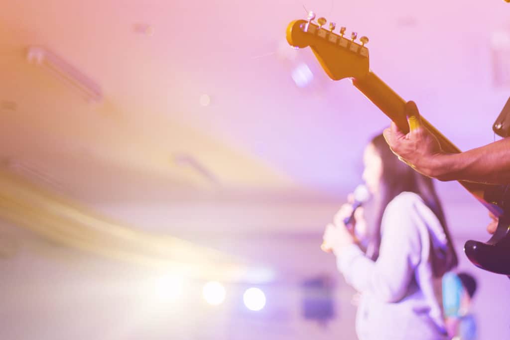 soft focus hands man playing guitar on stage in worship night co