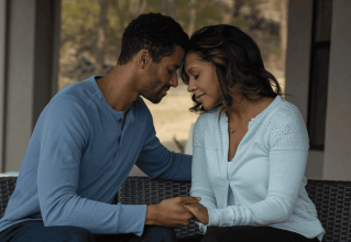 Young African-American couple sitting, facing each other, and being affectionate