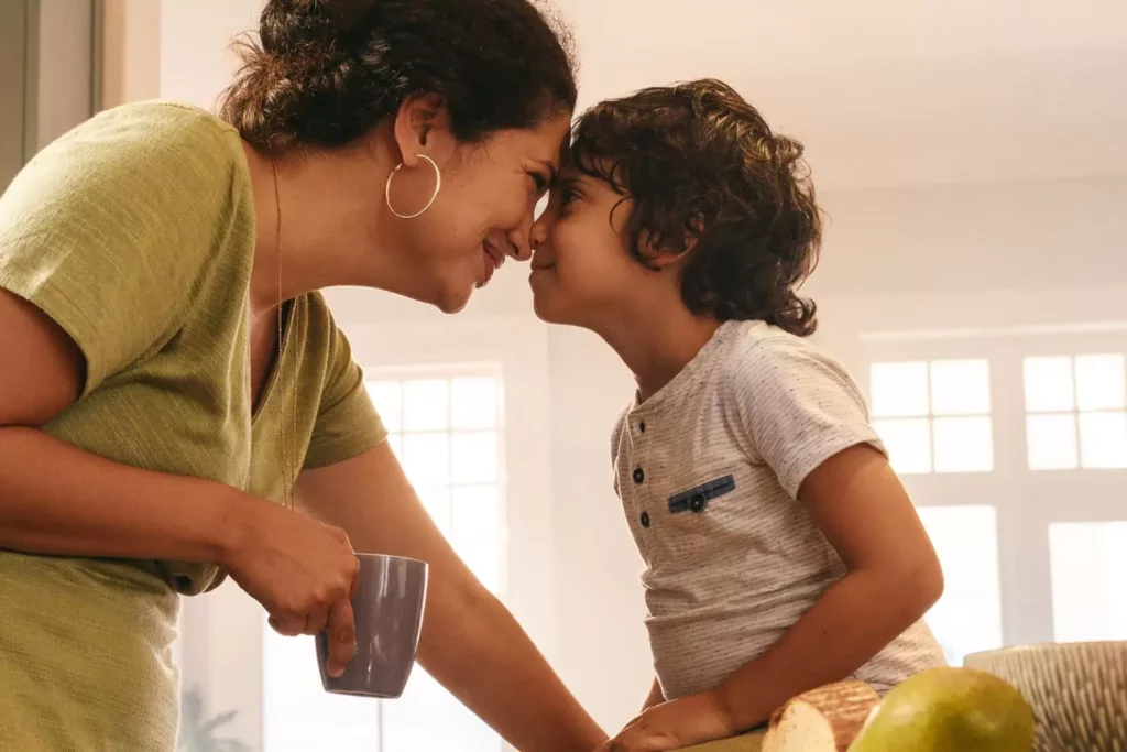 Mother and son lovingly touching foreheads, nurturing gratitude.