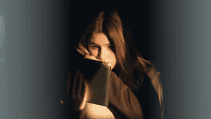 Witchcraft, teenage girl sitting in the dark reading about witchcraft on her tablet.