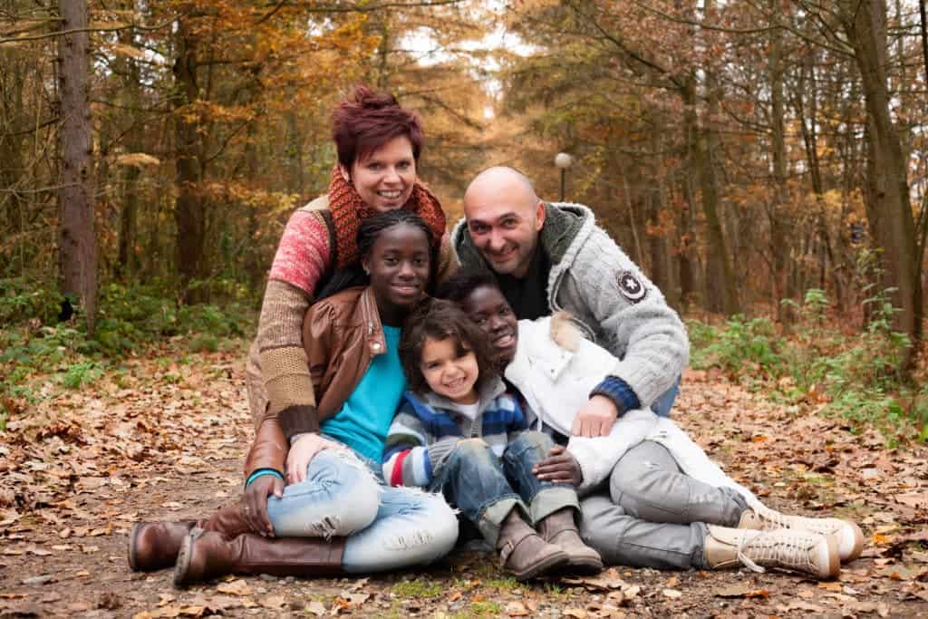 multi-cultural family sitting together because they fostered to adopt