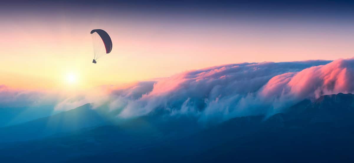 Paraglide silhouette in a light of sunrise above the misty Crimea valley.