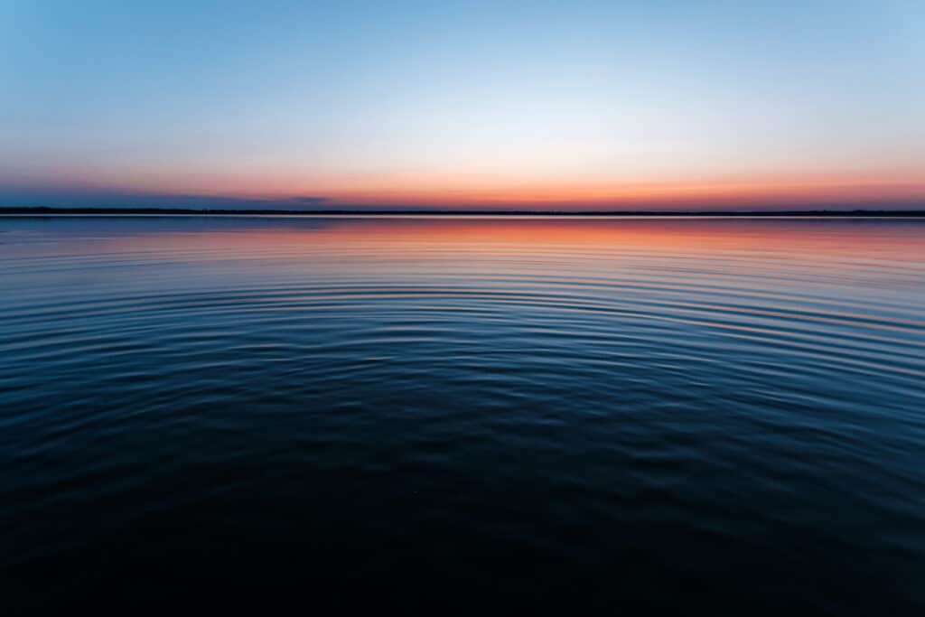 Circles on the water against a beautiful, pink sunset. The magic time of day.