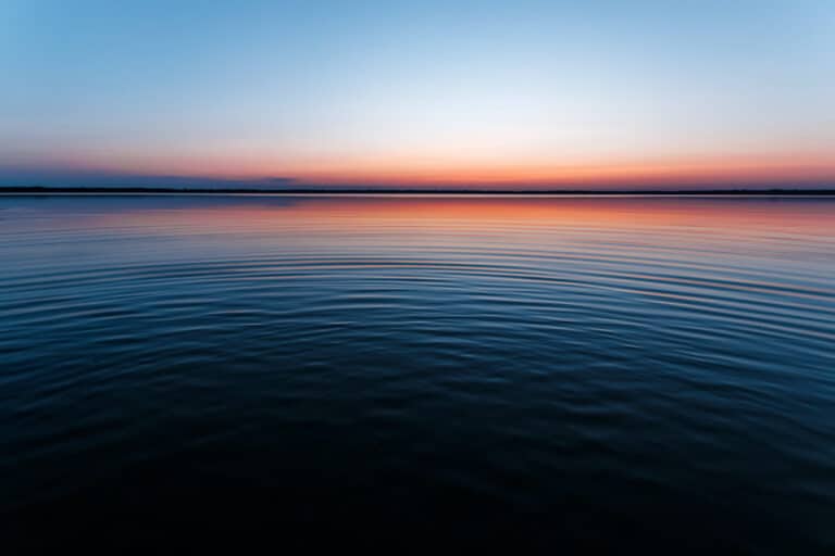 Circles on the water against a beautiful, pink sunset. The magic time of day.