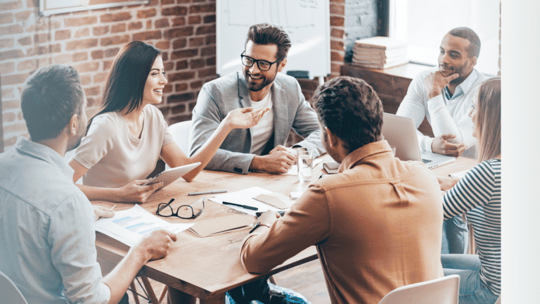 Team of men and women sitting around a table exemplifying the biblical view of work, which is others centered