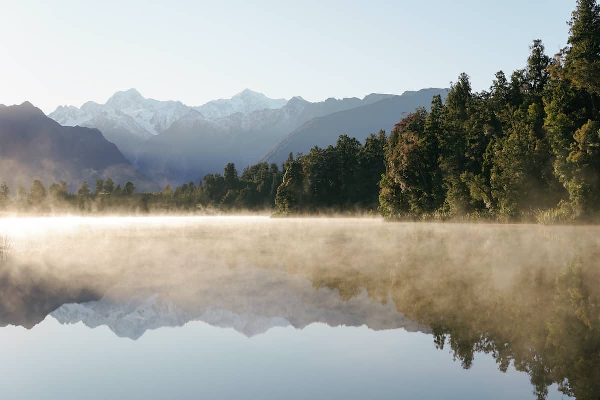 Capturing the tranquil serenity and reflecting the breathtaking beauty of New Zealand's Lake Matheson, with its calm waters and majestic mountain views.