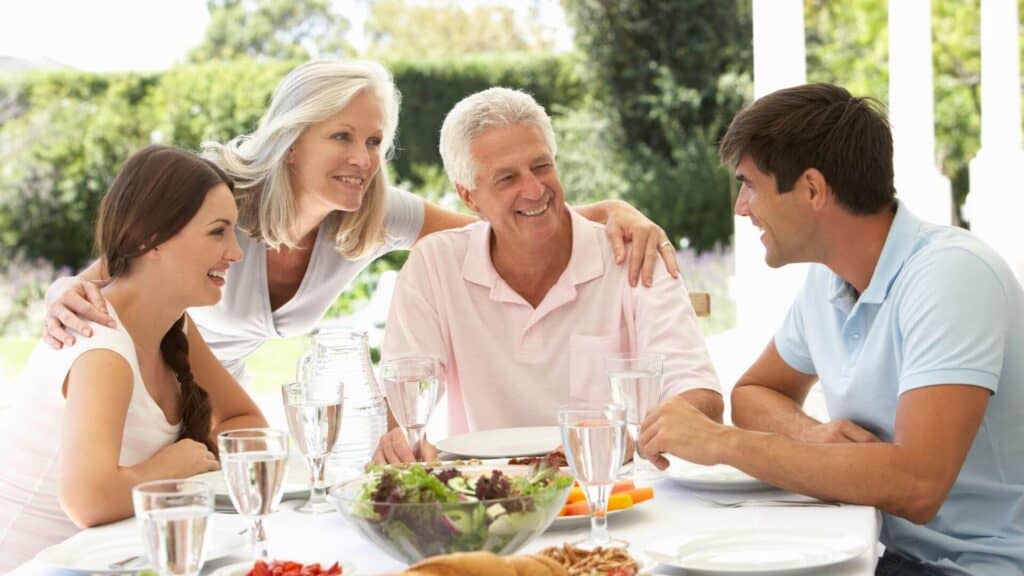 marriage blessings, middle-aged couple sharing a meal with daughter and future son-in-law outside on a sunny day