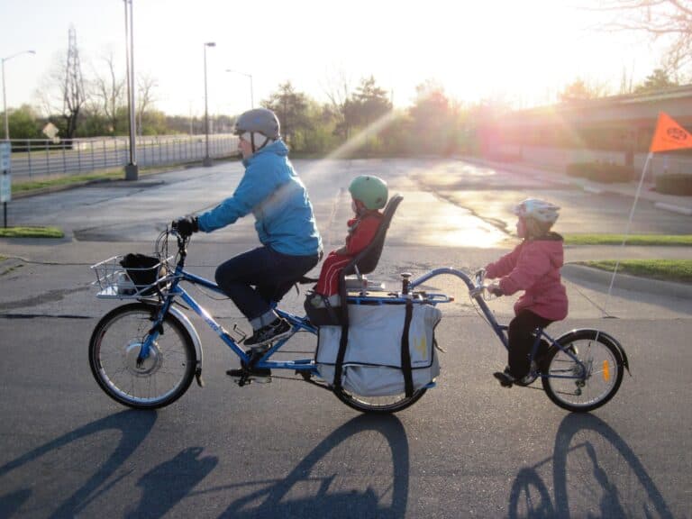 Father riding a tandem bike with his two children.