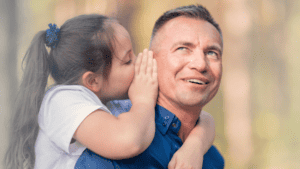 fathers and daughters. Little girl whispering something important in her father's ear