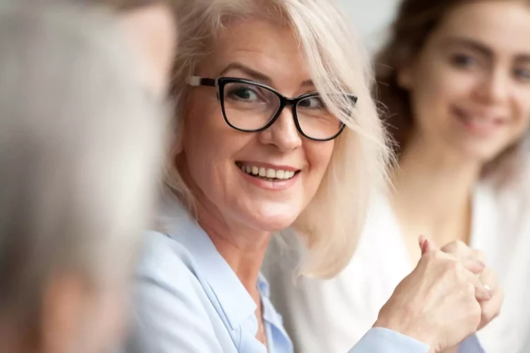 working moms sitting together smiling.