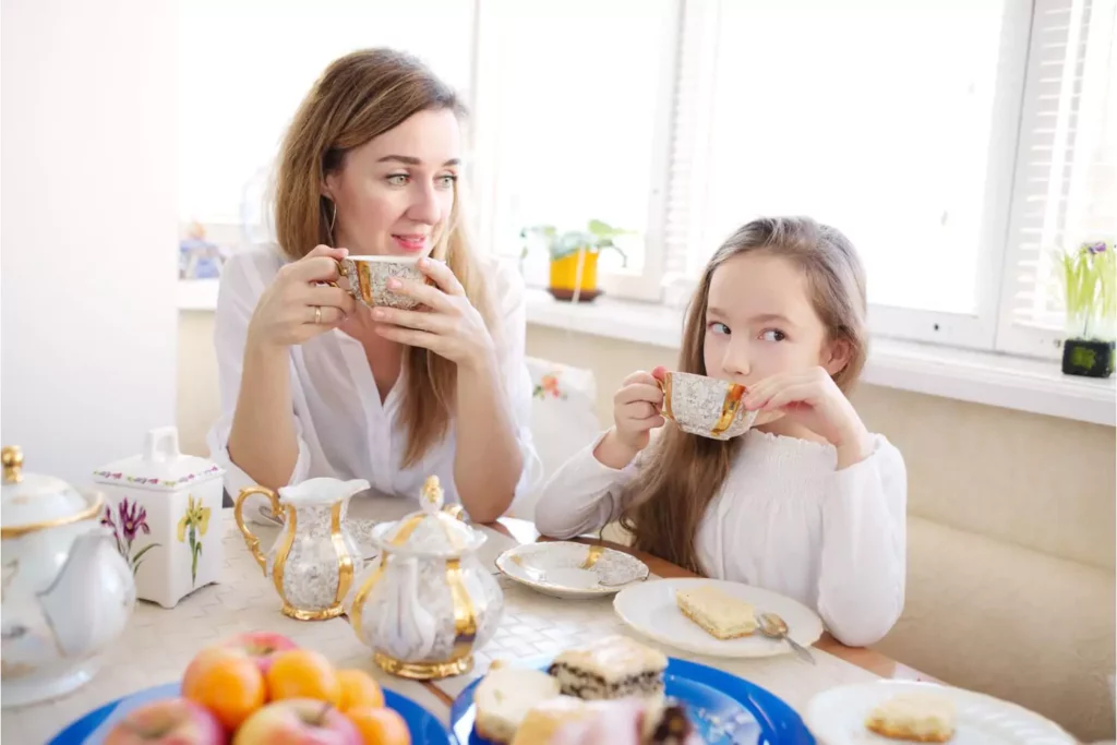 mother and daughter having a tea party to talk about her daughter's first period as her mother prepares her girl for womanhood.
