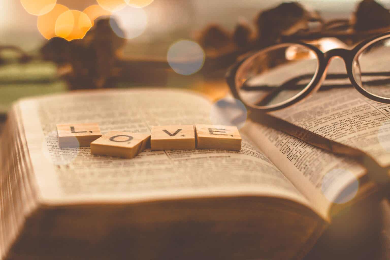 God's love for us love in scrabble tiles atop a Bible