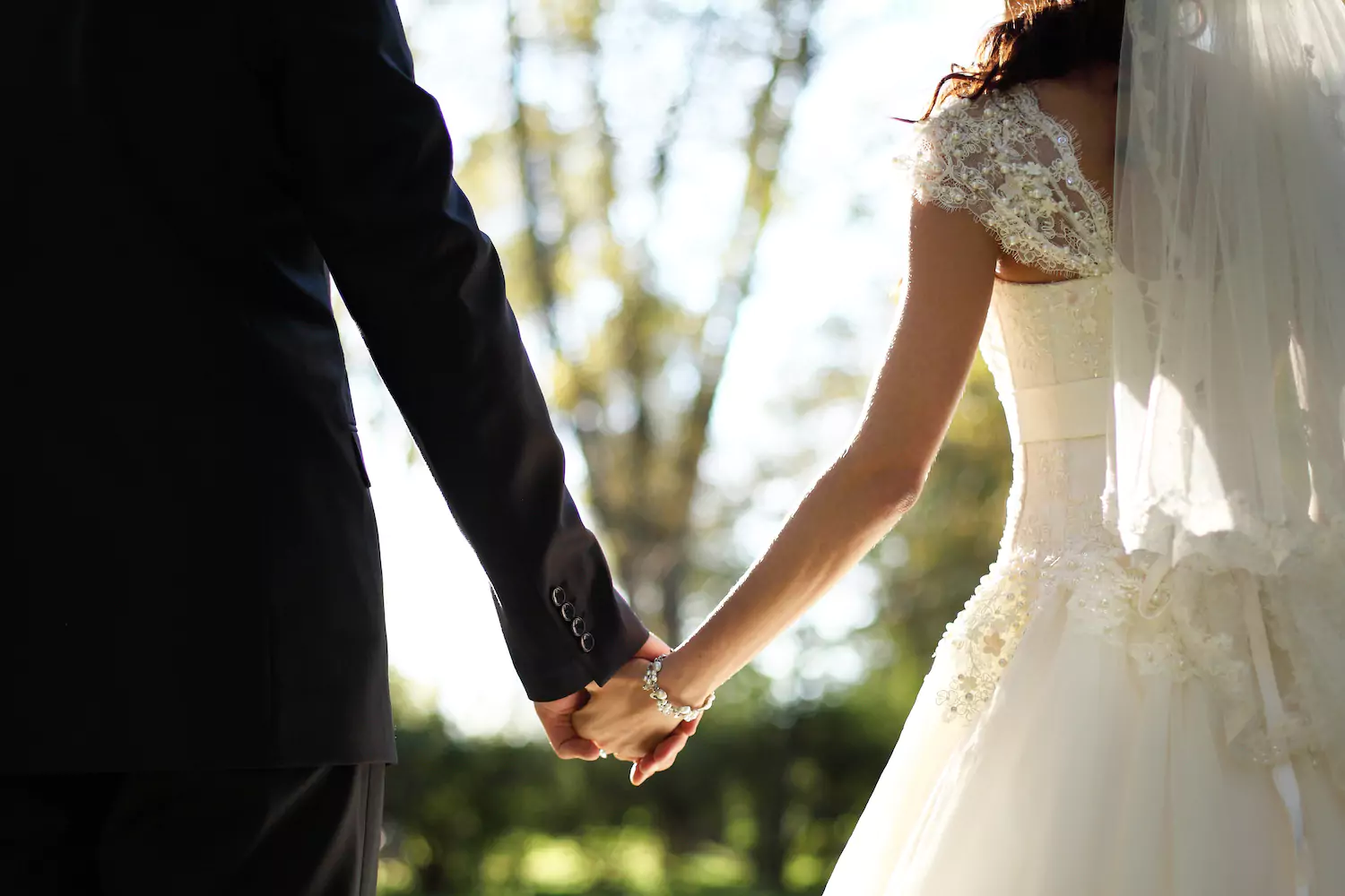 A couple holding hands on their wedding day.