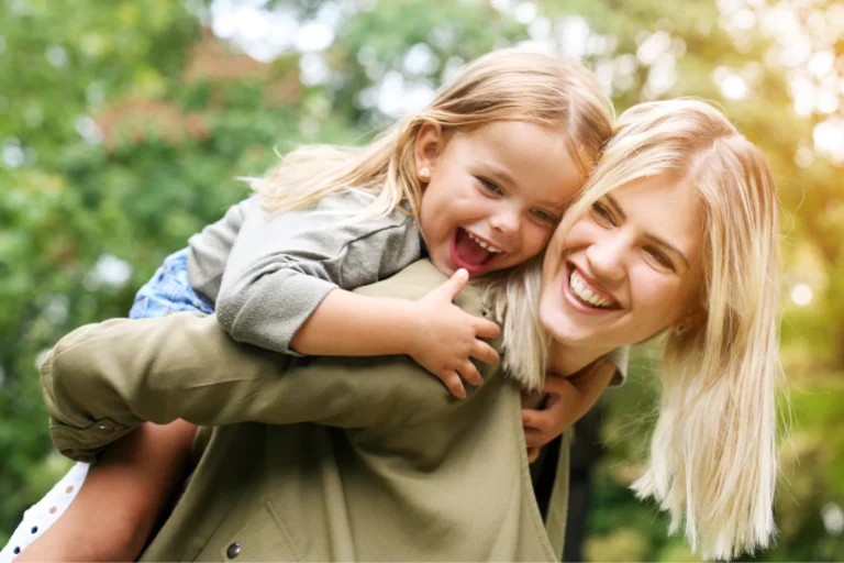 single mom with laughing little girl on her back
