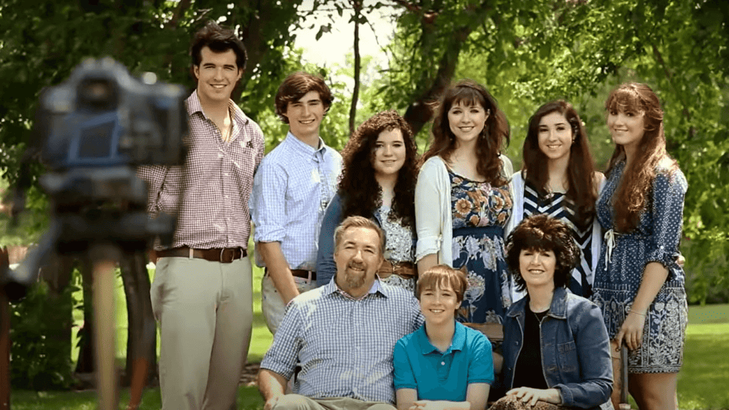 A family of nine having a family picture taken of them outside