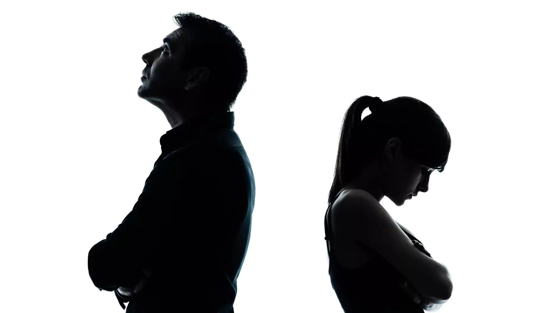 Silhouette of a man and woman standing with their arms crossed, facing away from each other. They have been fighting in marriage and wonder what the Bible says about conflict.