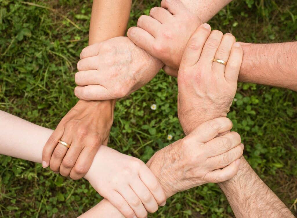 hands holding each other's wrists in a circle working together