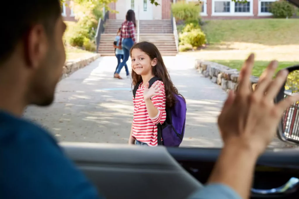 father saying goodbye to his little girl as she heads into school and says a prayer for his kids