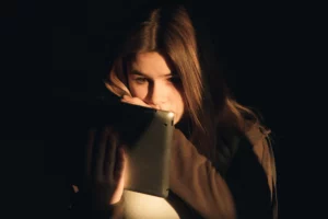 Witchcraft, teenage girl sitting in the dark reading about witchcraft on her tablet.