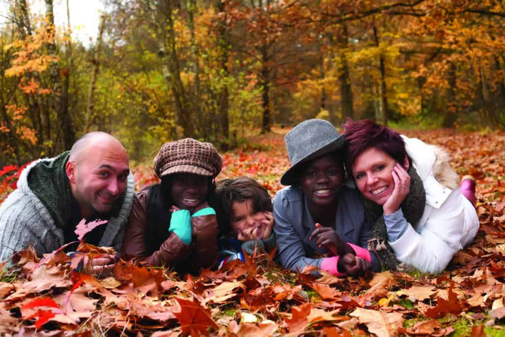 Happy family with foster children in the forest