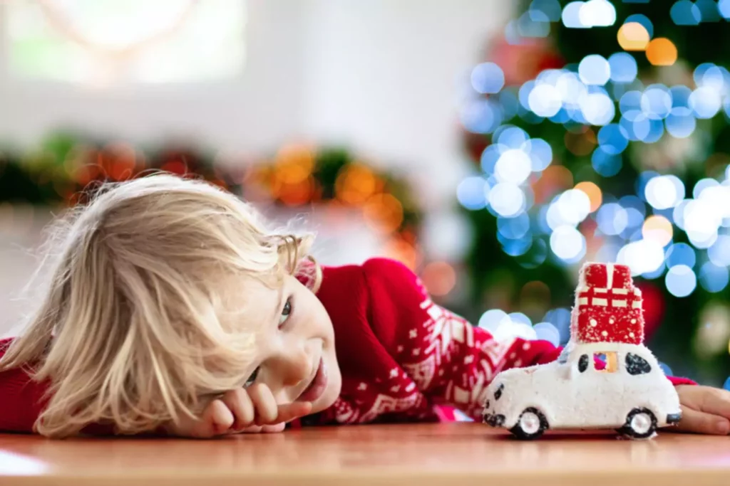 Christmas on a budget, this little blonde boy is playing with a car