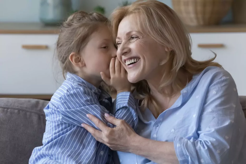 teaching kids gratitude. Little girl whispering in her mom's ear, expressions of gratfulness.