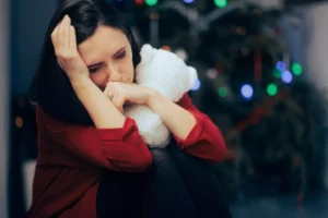 Christmas mourning, this young mom is mourning the loss of her child at Christmas as she hugs her teddy bear.