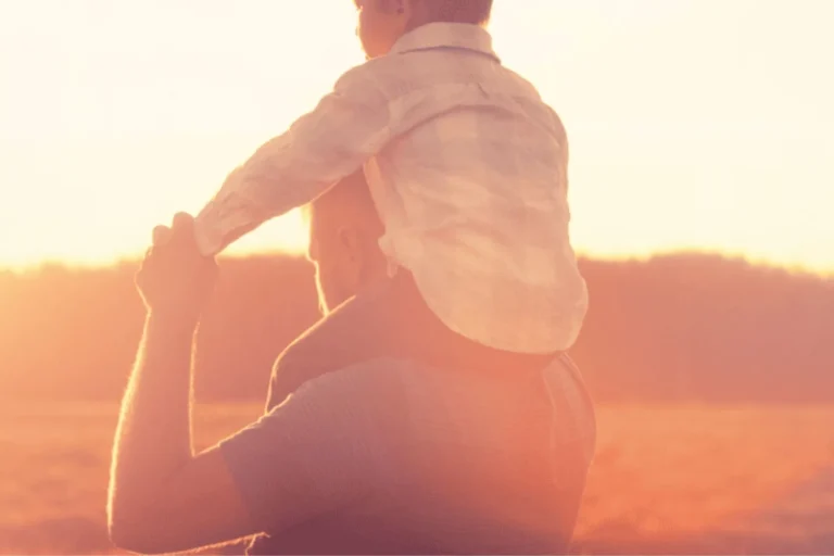 Boy riding on his father's shoulders
