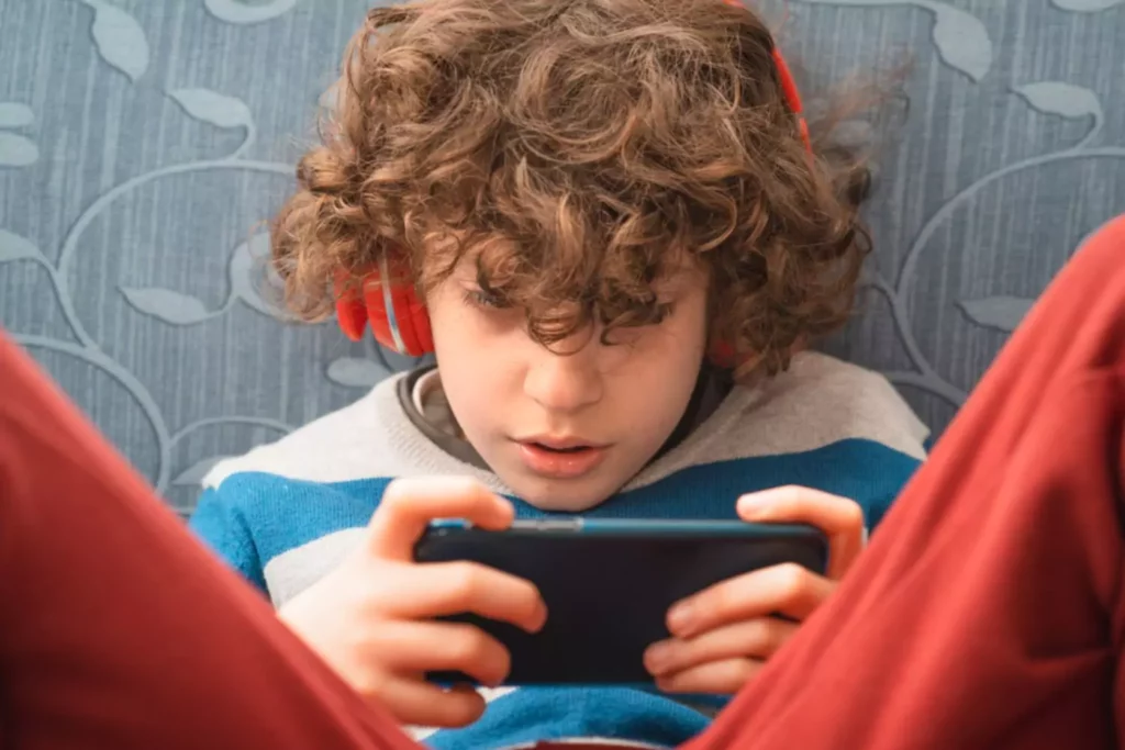 Young boy listening to music on his smart phone