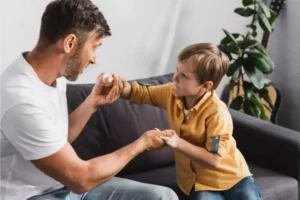 Father talking to his son on the couch, holding hands, and talking about being thankful