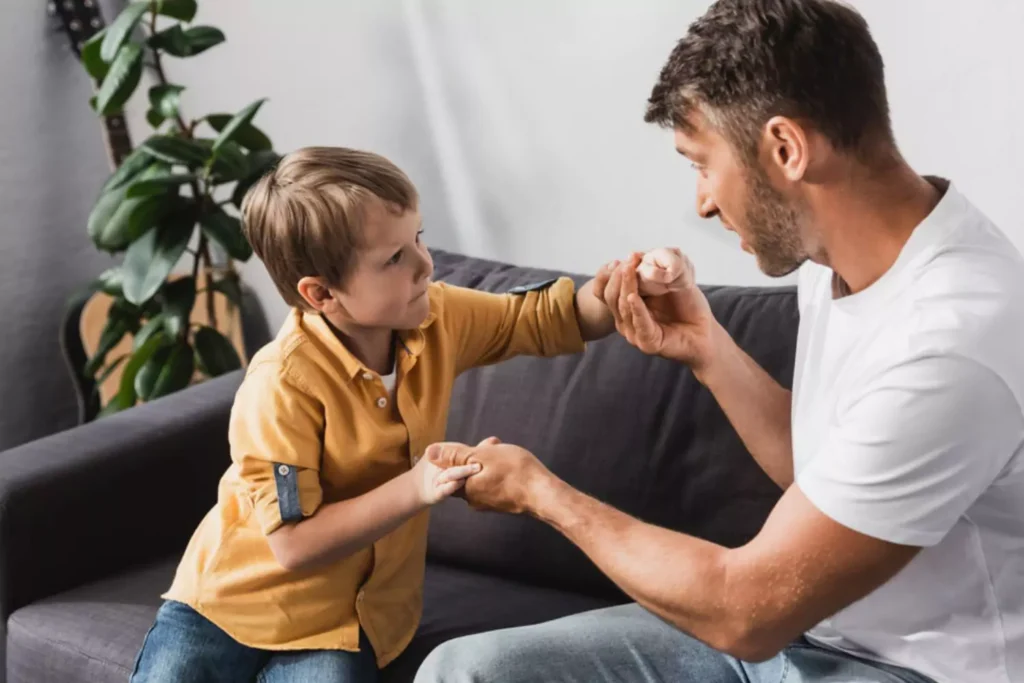 Father talking to his son on the couch, holding hands, and talking about being thankful