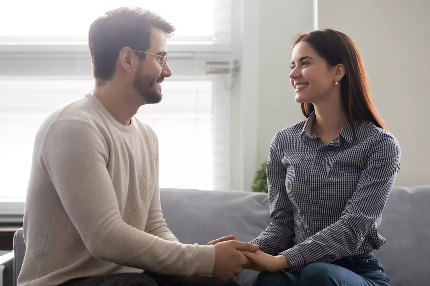 Man and a woman sitting on the couch showing respect for one another.