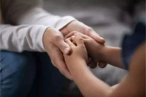 Parent holding hands with a child